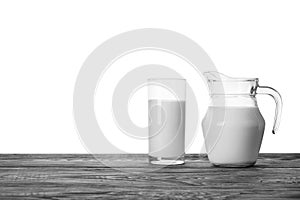 Jug and glass of milk on a wooden table