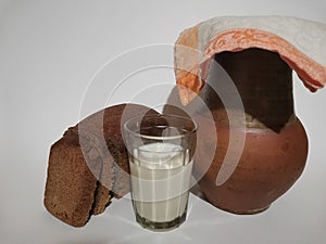 A jug of glass with rye bread milk on a white background