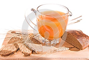 Jug with kvass (kvas), bread and ears on wooden board.