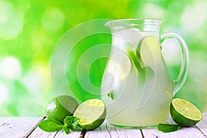 Jug of limeade against a green outdoor background