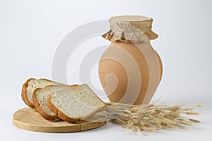 Jug of milk with freshly baked white bread and wheat ears