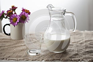 A jug of milk and a glass in a rustic style on a burlap tablecloth,,