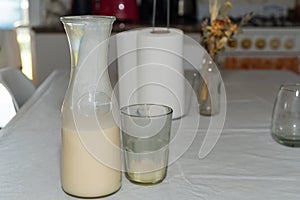 jug with milk, glasses, napkins and vase with dried flowers on the table