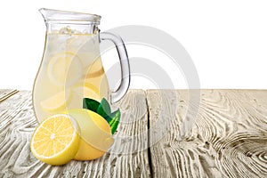 Jug or pitcher of lemonade with lemons on foreground standin on photo