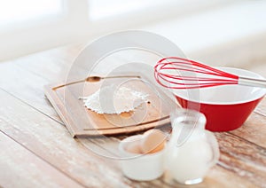 Jugful of milk, eggs in a bowl and flour