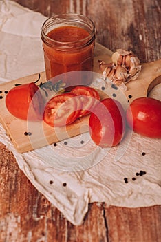 Juice, fresh tomatoes, garlic and spices on the kitchen table