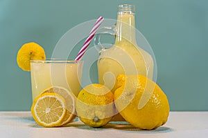 Juice and lemon fruit of the Sicilian species Citrus limon on a clear surface and green background