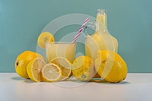 Juice and lemon fruit of the Sicilian species Citrus limon on a clear surface and green background