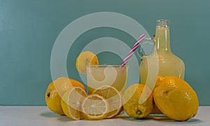 Juice and lemon fruit of the Sicilian species Citrus limon on a clear surface and green background