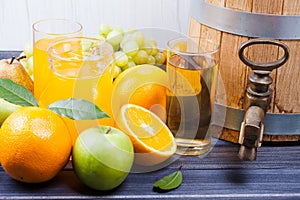 Juices, barrel and fruits on wooden table