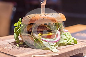 Juicy American cheeseburger on a wooden board