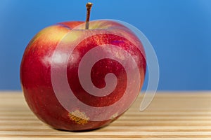 Juicy apple isoloated on blue background on the desk