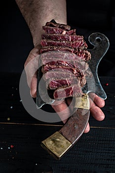 Juicy Beef rump steak from marble beef medium rare served on old meat butcher, close-up. cooking meat steak by chef hand