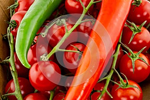 Juicy bright mature cherry tomato close-up large long peppers peppers hot peppers green red