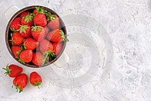 Juicy, bright and sweet strawberries in a bowl on a white concrete table