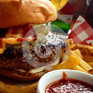 Juicy burger with gorgonzola cheese, bacon, fries, ketchup and beer