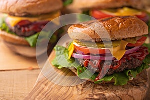 Juicy burgers on a wooden background with french fries. Home recipes, or cafe. Calorie and junk food