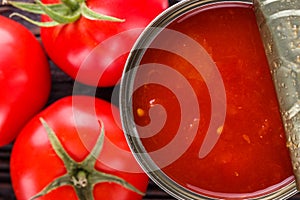 Juicy canned tomatoes on wooden rustic background