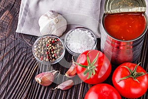 Juicy canned tomatoes on wooden rustic background