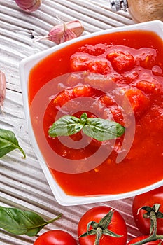 Juicy canned tomatoes on wooden rustic background