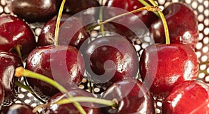 juicy cherries in a metal colander close-up