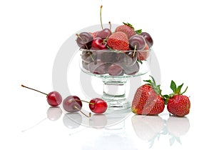 Juicy cherries and strawberries in a glass bowl isolated on whi