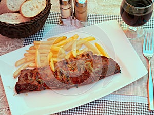 Juicy churrasco veal ribs with crispy french fries photo