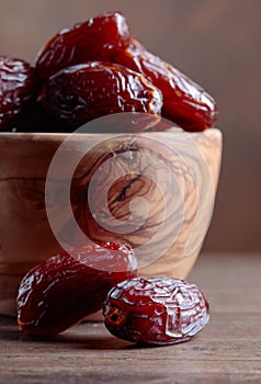 Juicy dates on wooden table .