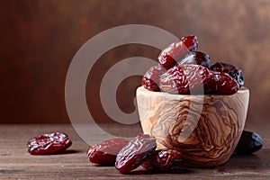 Juicy dates on wooden table .