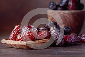 Juicy dates on wooden table .