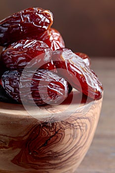 Juicy dates on wooden table .