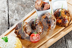 Juicy delicious meat cutlets and hominy ,Corn porridge Polenta, with goat cheese on cutting board on wooden background