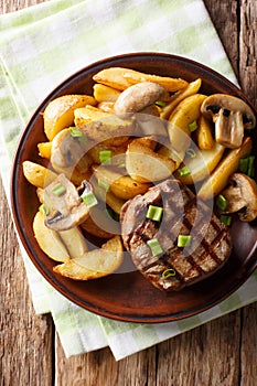 Juicy fillet mignon with fried potato wedges and mushrooms close