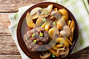 Juicy fillet mignon with fried potato wedges and mushrooms close