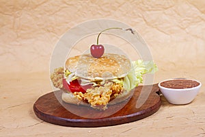 Juicy fish burger, hamburger or cheeseburger with one fish patties, with sauce. Concept of American fast food. Copy space