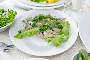 Juicy, fragrant herring, sliced and decorated with greenery close-up.