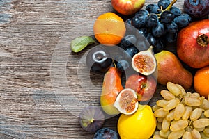 Juicy fresh fruit on a wooden dark table, top view.