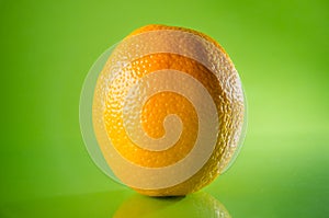 Juicy fresh orange isolated on green background, horizontal shot