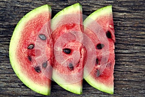 Juicy fresh red watermelon on the table. Watermelon sliced into pieces on a wooden texture background.