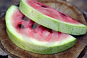 Juicy fresh red watermelon on the table. Watermelon sliced into pieces on a wooden texture background.