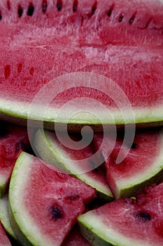 Juicy fresh red watermelon on the table. Watermelon sliced into pieces on a wooden texture background.