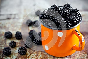 Juicy fresh ripe blackberry in vintage cup