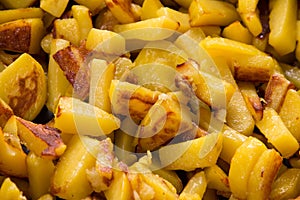 Juicy fried potatoes in a frying pan, homemade roasted potatoes with a crispy crust close up.