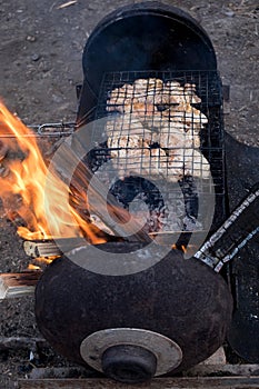 Juicy grilled chicken meat. The meat is cooked on a hot charcoal barbecue grill, fire and sparks from below. Dish for a grilled