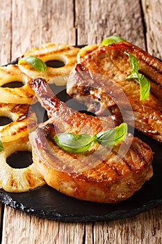 Juicy grilled pork chop in honey glaze served with pineapple and