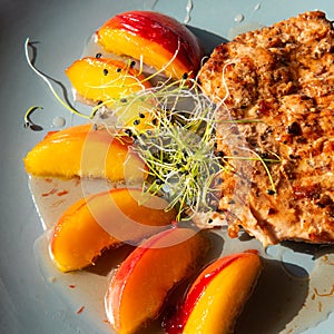 Juicy grilled turkey steak with caramelized peach. Square photo.