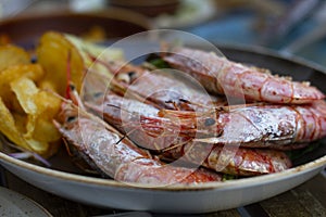 Juicy king prawns with potato chips aside