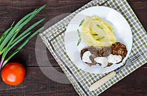 Juicy liver cutlet with sauce and mashed potatoes on a white plate.