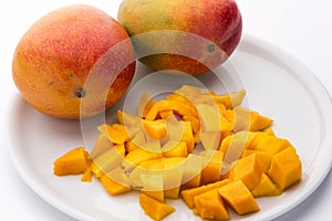 Juicy Mango Dice And Two Entire Mangos On A Plate