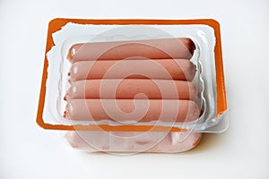 Juicy meat sausages in plastic packaging on a white background. Sausages in the group.Meat semi-finished product in a package